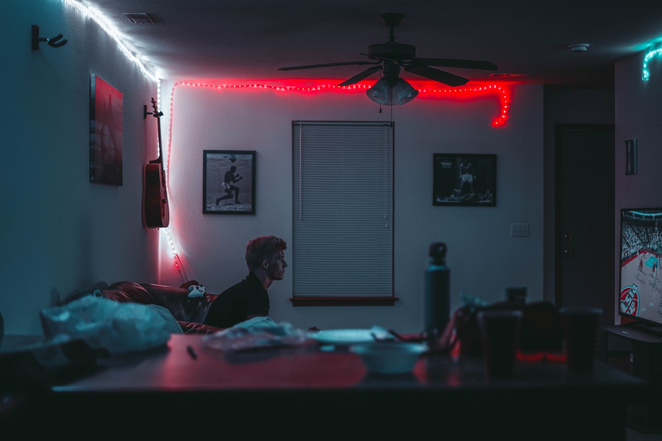 A teenager sitting in a dark room playing video games