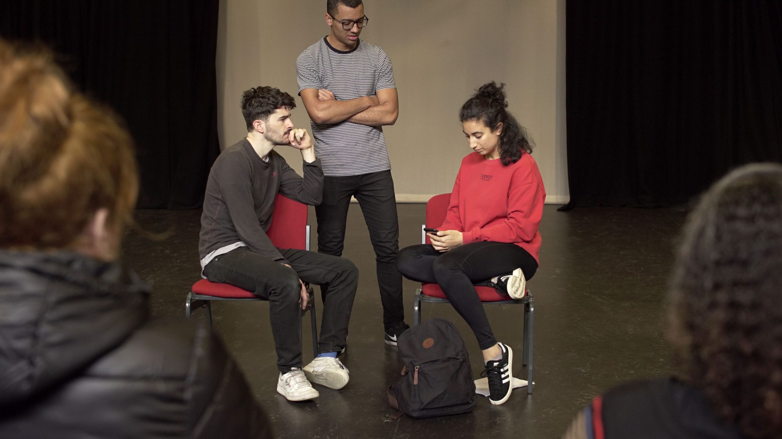 Three young people in a theatre workshop.
